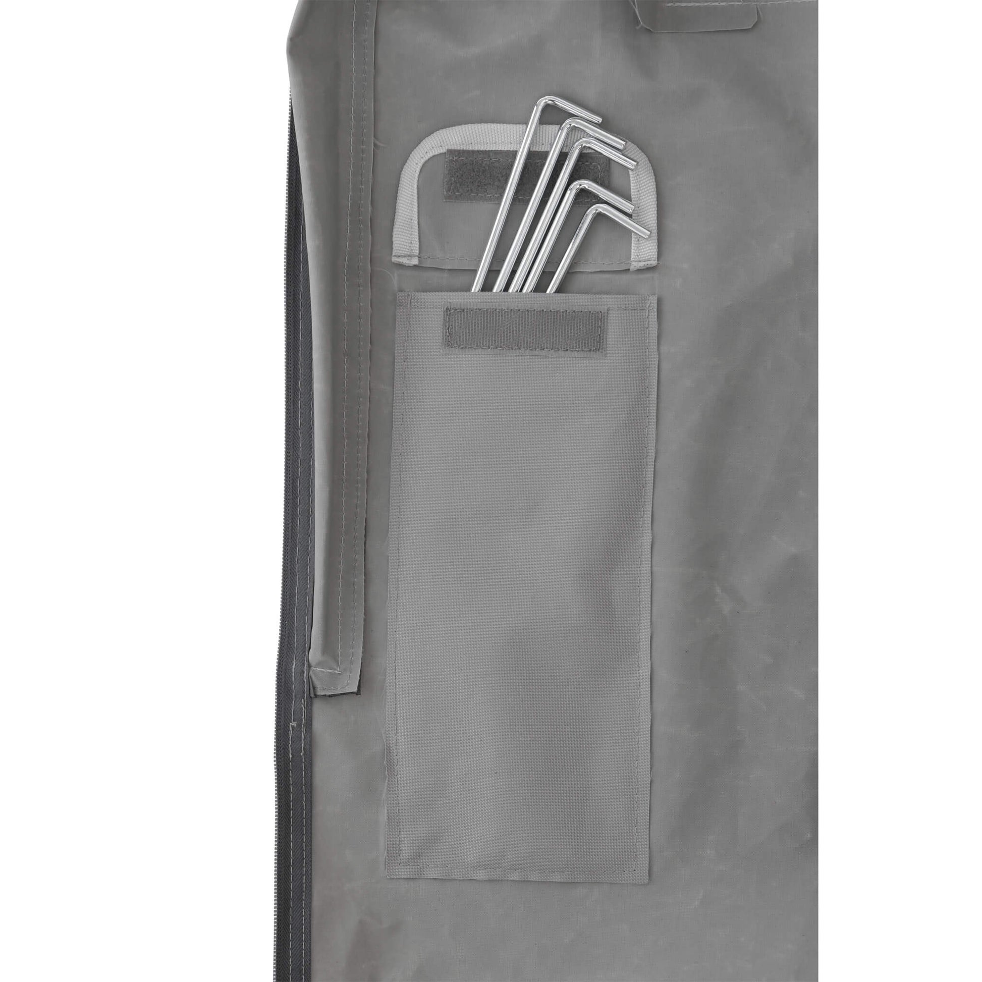 Close-up of CORE 10x10 center push canopy stake storage pocket in gray fabric with metal stakes neatly secured inside for easy access.
