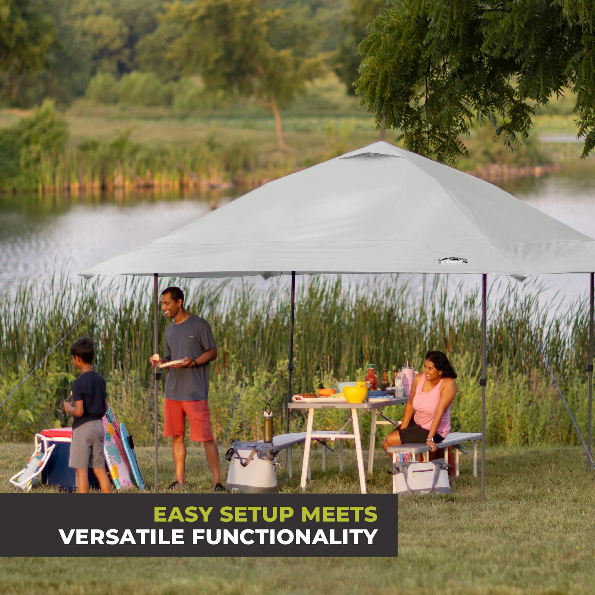 Family relaxing outdoors under the CORE 13x13 Center Push canopy top in gray, providing shade and ventilation for gatherings.