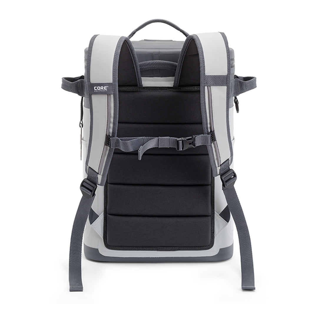 A sleek, grey and black Magnetic 24 Can Backpack Soft Cooler by CORE is shown from the back, featuring adjustable padded shoulder straps, a chest strap, and multiple compartments. The design is modern and structured, with a handle at the top for carrying.