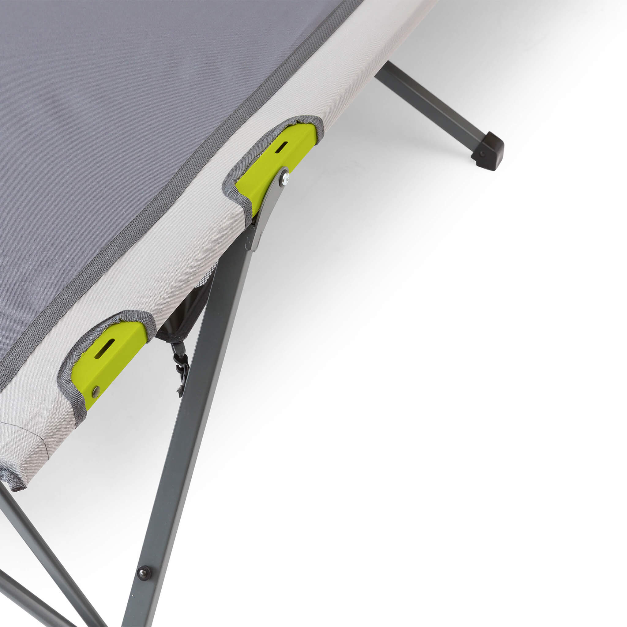 Close-up of a camping cot with a gray cushion and a green frame with slots for a cup holder.