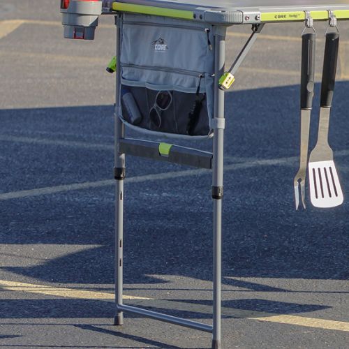 CORE FlexRail camping table with adjustable legs, integrated storage bag, hanging utensils, and cup holder, highlighting single-hand height adjustment and modular outdoor cooking setup
