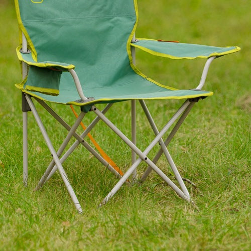 A green folding camp chair with lime yellow trim and a silver metal frame, set on a green grassy lawn.
