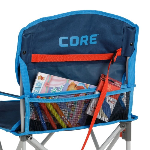 Rear storage pocket on a blue folding youth chair, featuring a black mesh compartment holding children’s books and small items, with an orange strap and the “CORE” logo visible above.