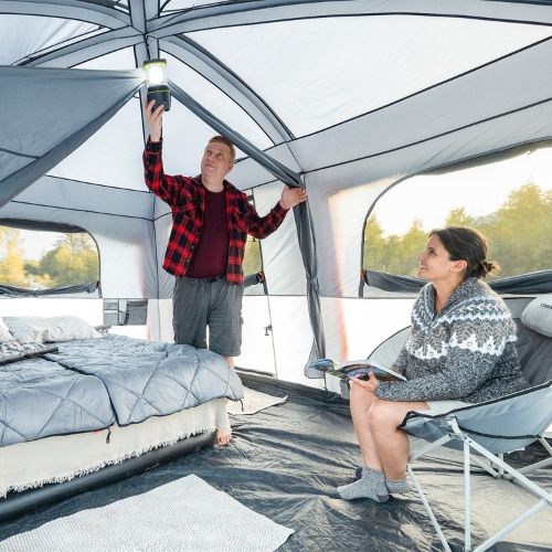 Two people inside a CORE 10 person straight wall cabin tent with full rainfly.