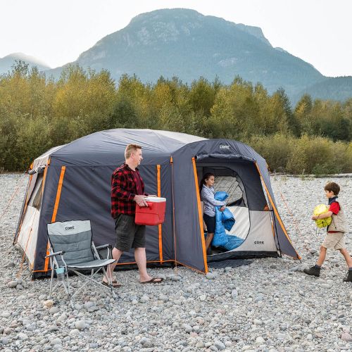 Family camping outdoors with a CORE 10 person straight wall cabin tent with full rainfly.