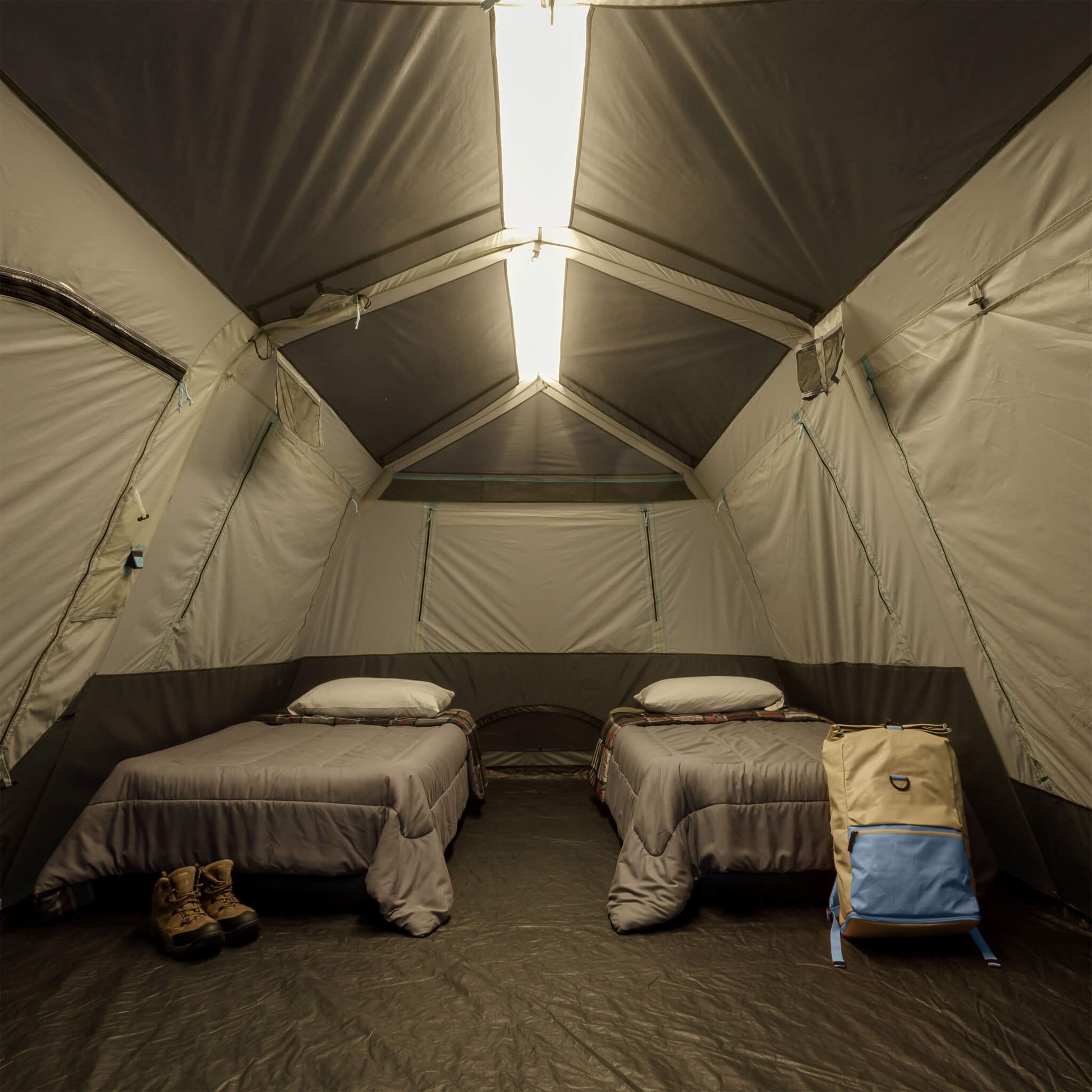 Inside CORE 10 person lighted instant cabin tent with air mattresses, showing overhead light bar on high for nighttime visibility and comfort.