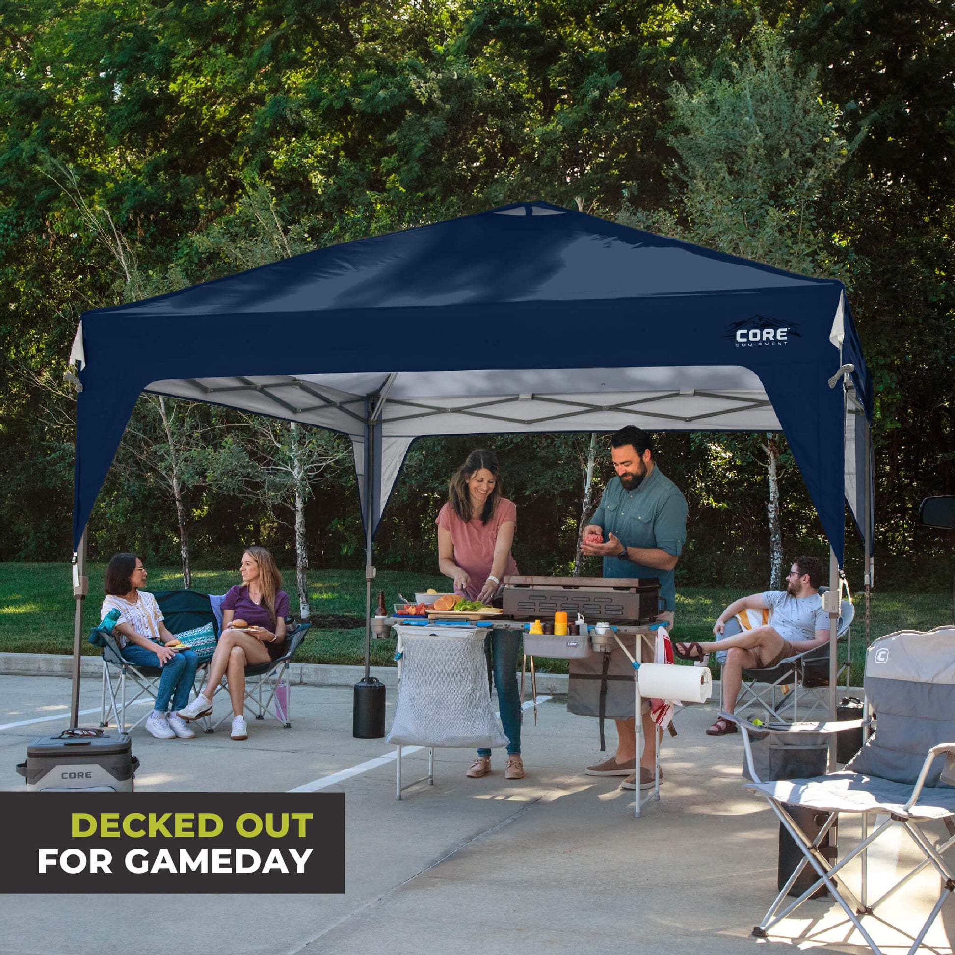Friends relaxing outdoors under the CORE 10x10 Center Push canopy top in navy, providing shade and ventilation for gatherings.