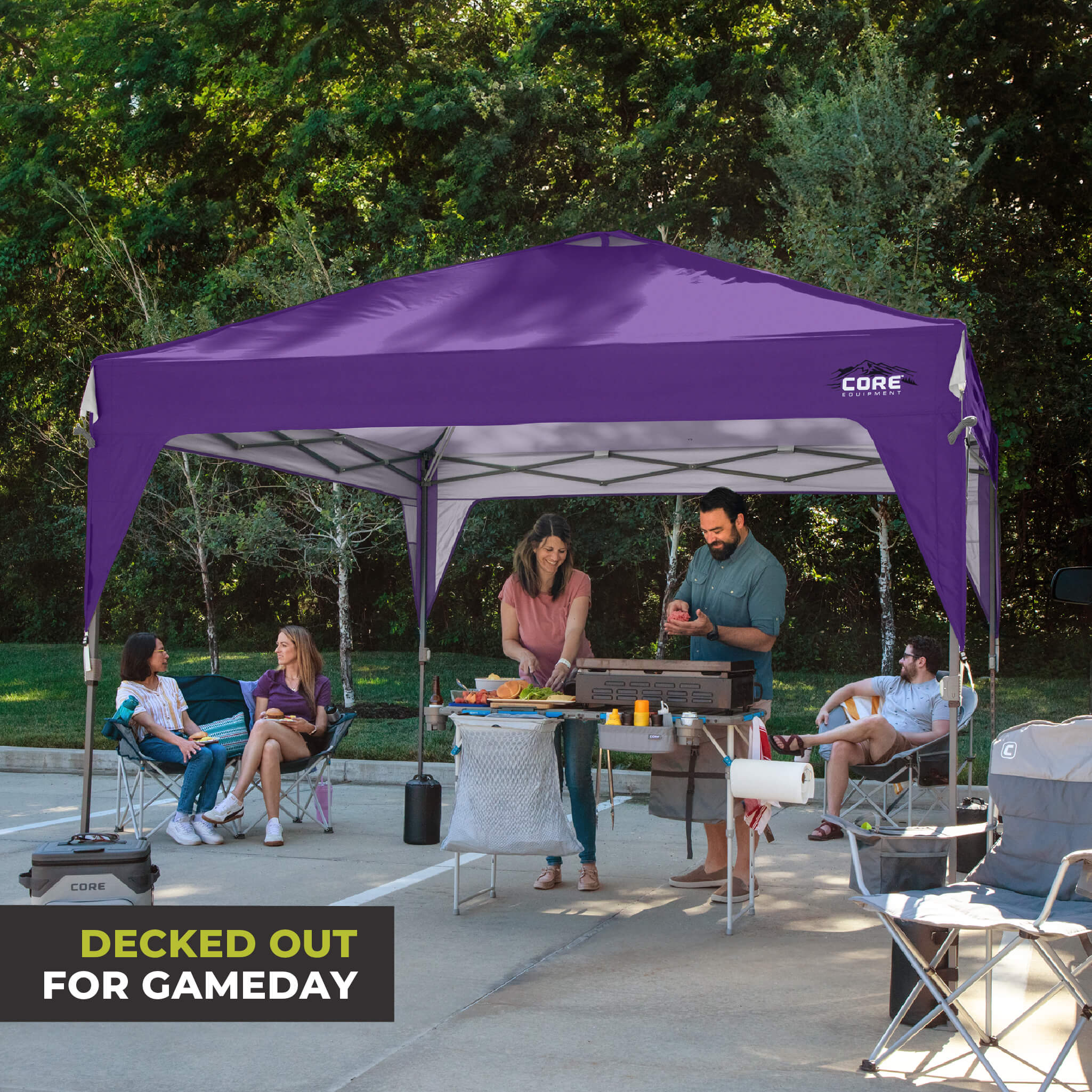 Friends relaxing outdoors under the CORE 10x10 Center Push canopy top in purple, providing shade and ventilation for gatherings.