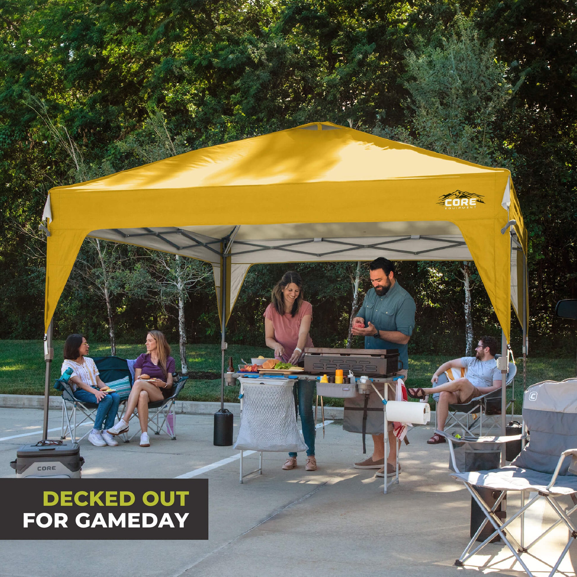 Friends relaxing outdoors under the CORE 10x10 Center Push canopy top in yellow gold, providing shade and ventilation for gatherings.