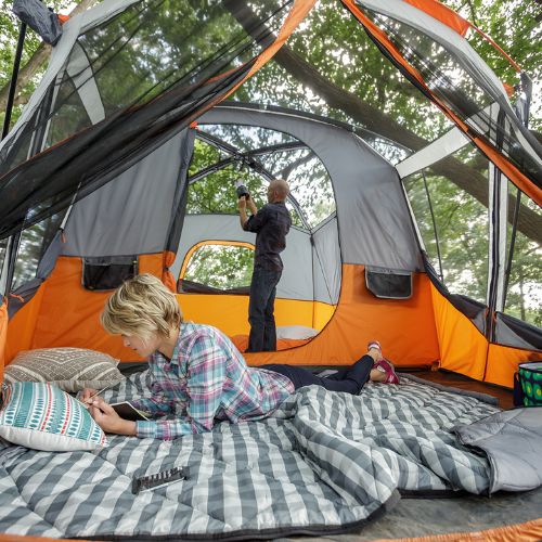 Two people inside a CORE 11 person cabin tent with screen room.