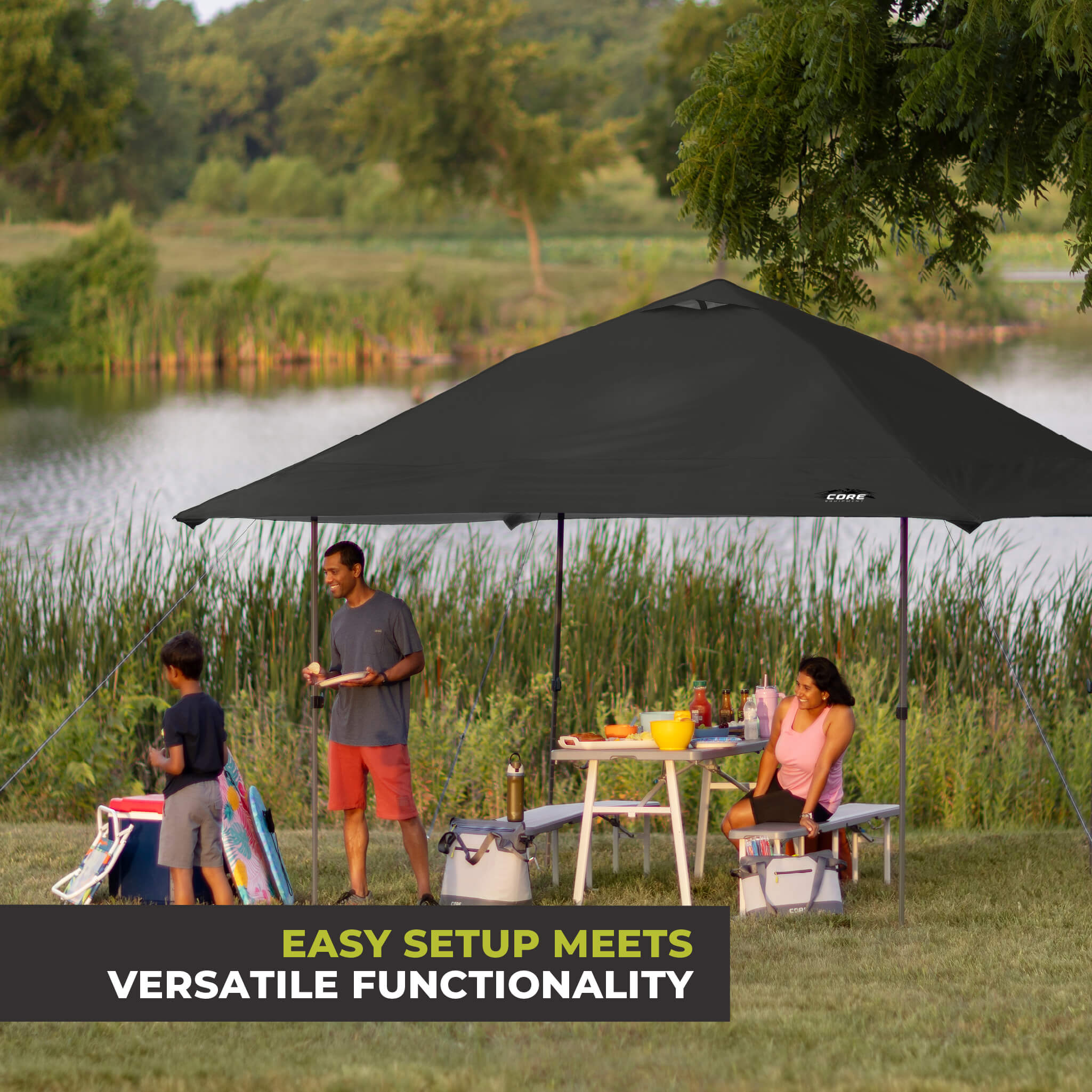 Family relaxing outdoors under the CORE 13x13 Center Push canopy top in black, providing shade and ventilation for gatherings.