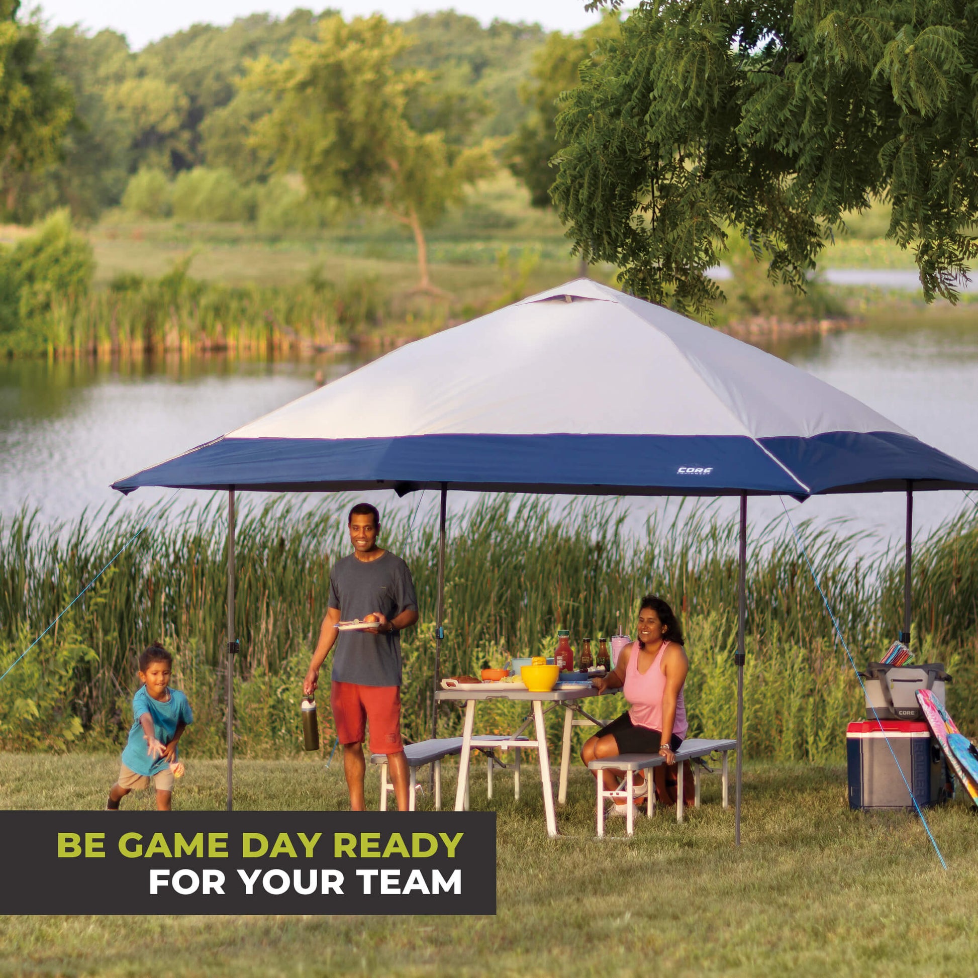 Family relaxing outdoors under the CORE 13x13 Center Push canopy top in gray/navy, providing shade and ventilation for gatherings.