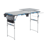 CORE folding cook table with prep table top, trash bag holder, cup holders, and accessory bag attached.