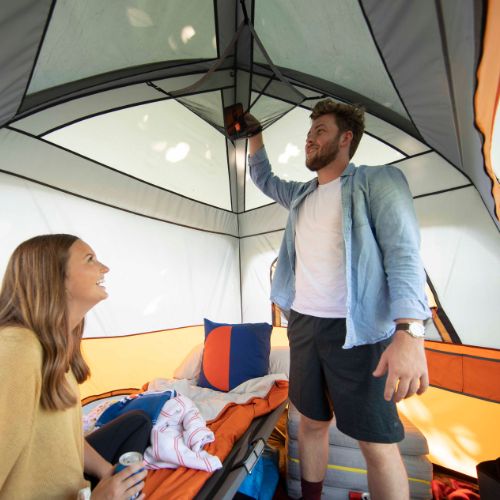 Two people inside a CORE 4 person straight wall cabin tent.