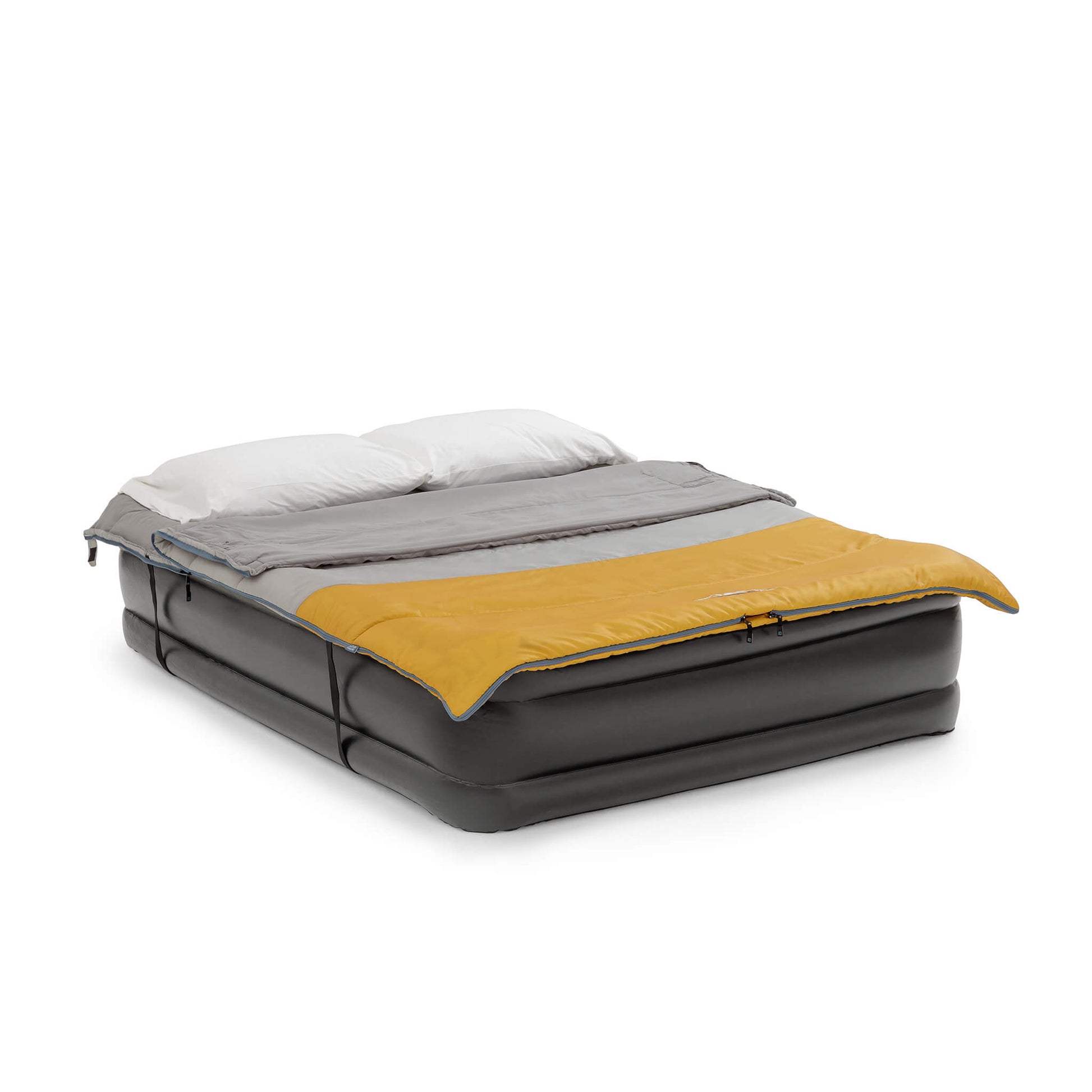 Inflatable double camping bed with a gray and yellow CORE double sleeping bag lying on top with two pillows.