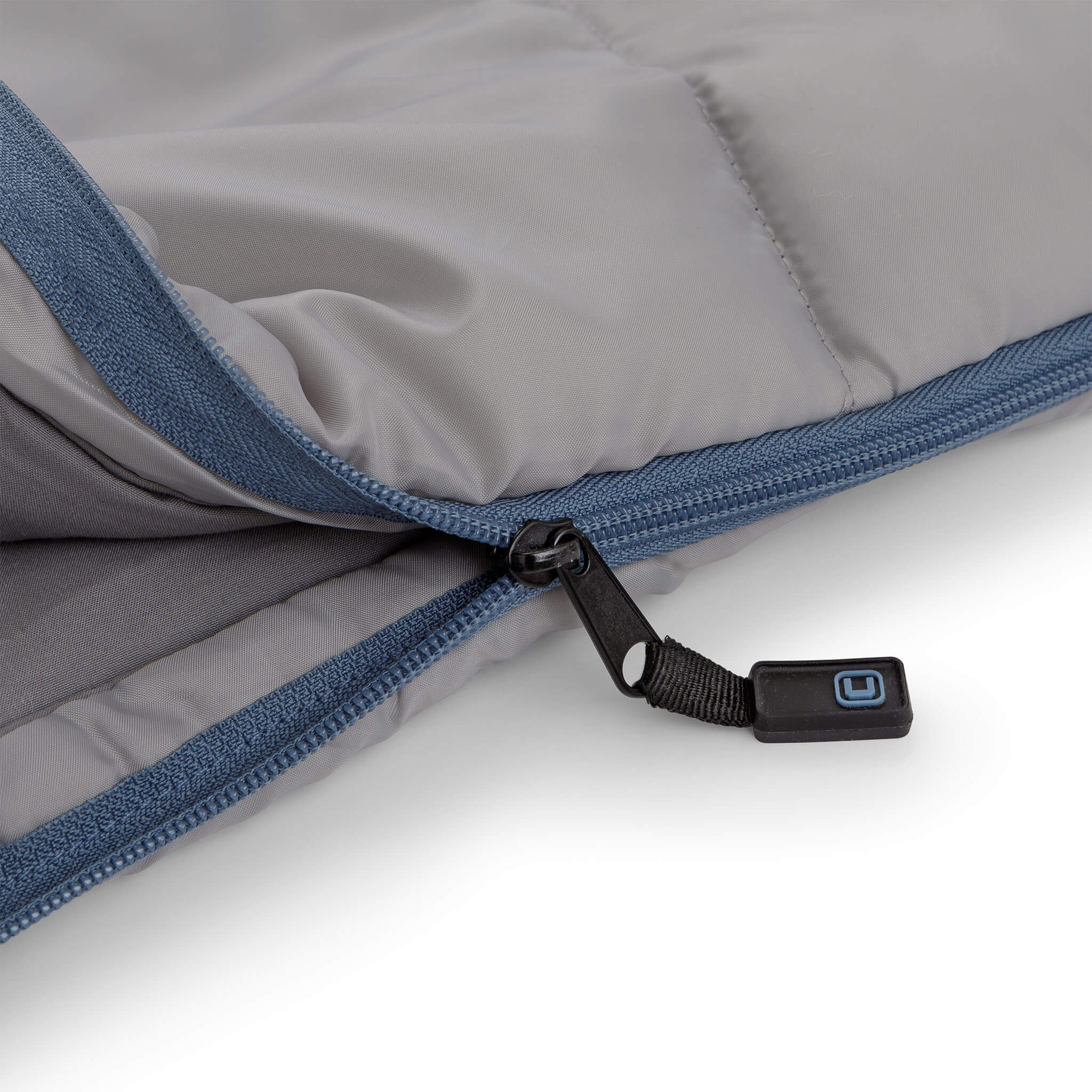 Close-up of CORE sleeping bag zipper with blue trim and black pull tab.