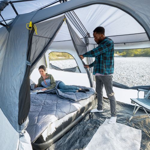 9 person instant cabin tent with full rainfly interior showing a couple setting up the air mattress.