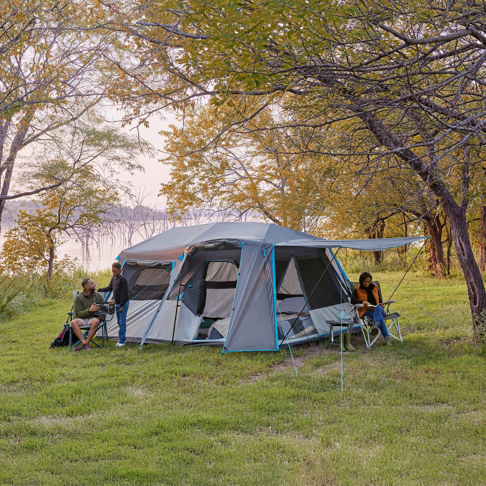 Family enjoying time outside the CORE 9 lighted person instant cabin tent with full rainfly.