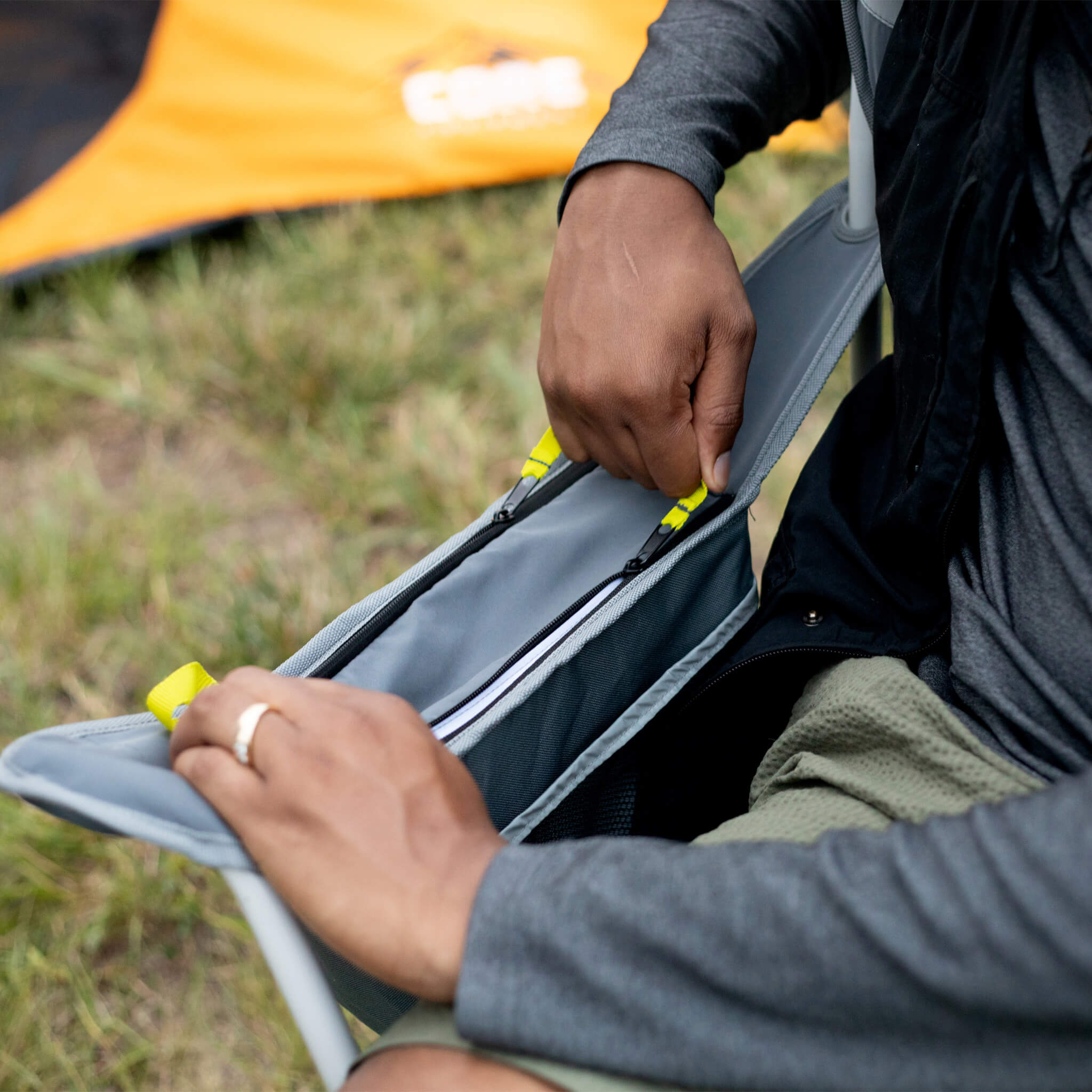 Close-up of a CORE cooler quad chair showing an insulated cooler pocket with a zipper closure.