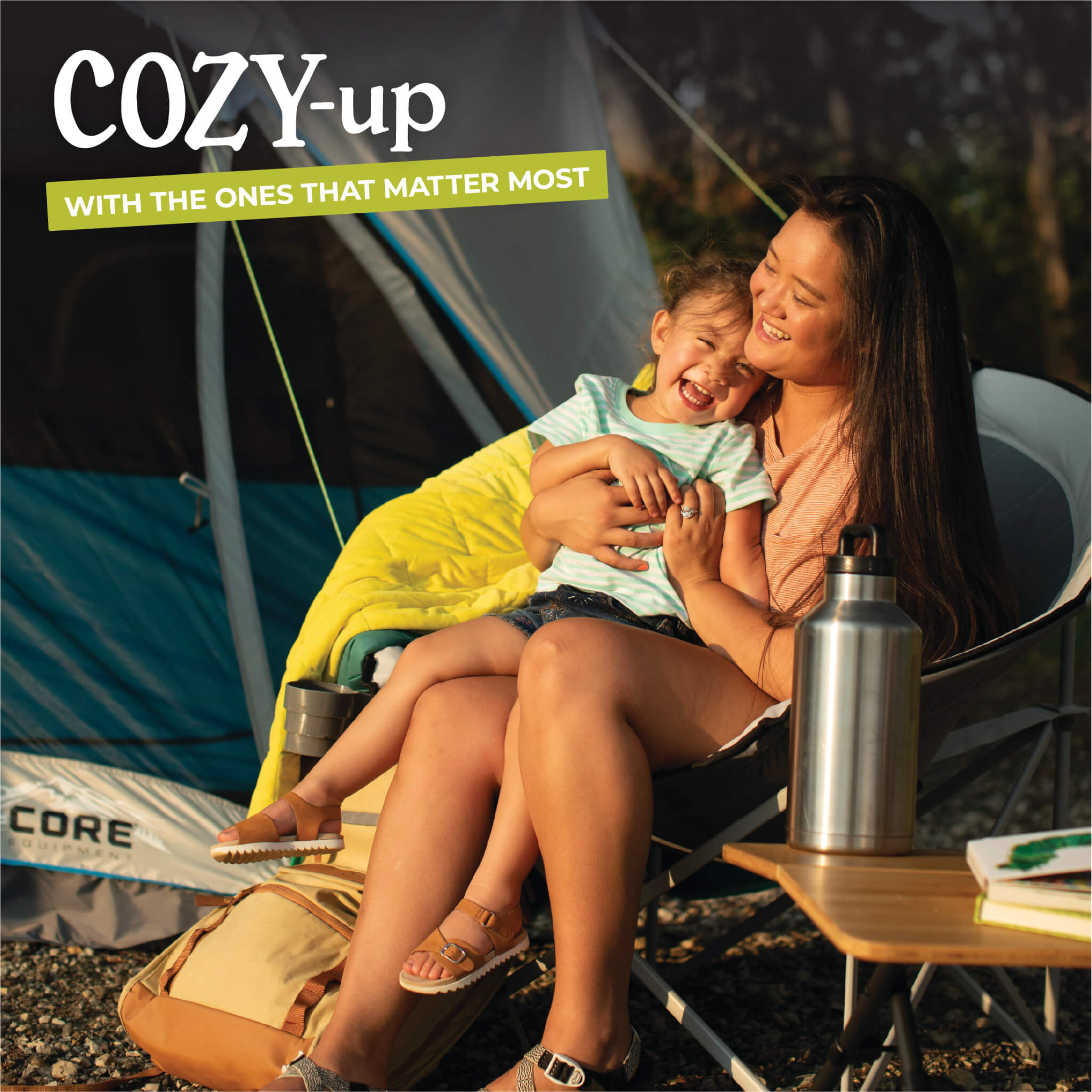 Mother relaxing with child in padded CORE gray moon chair inside tent.