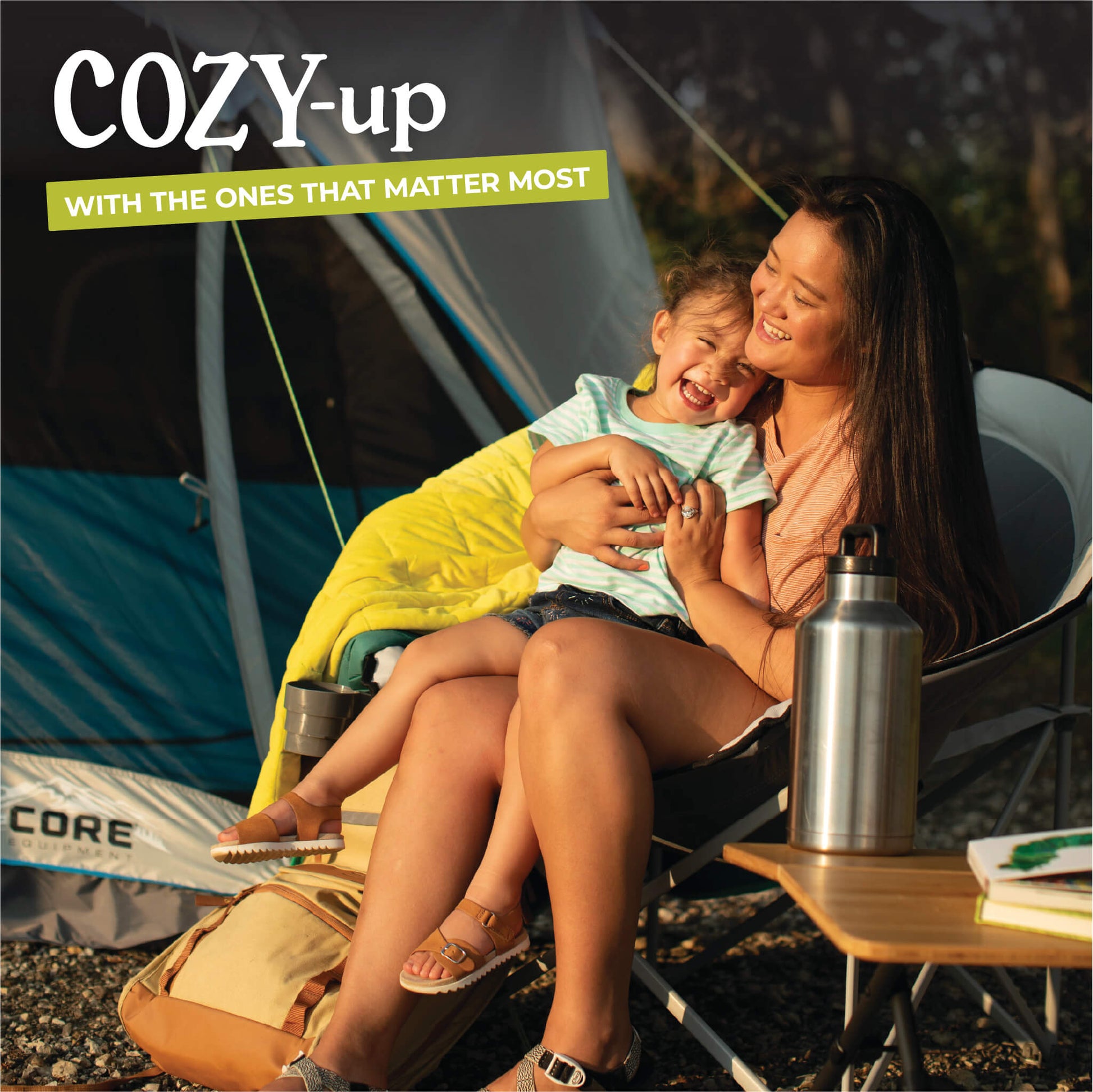 Mother relaxing with child in padded CORE gray moon chair inside tent.