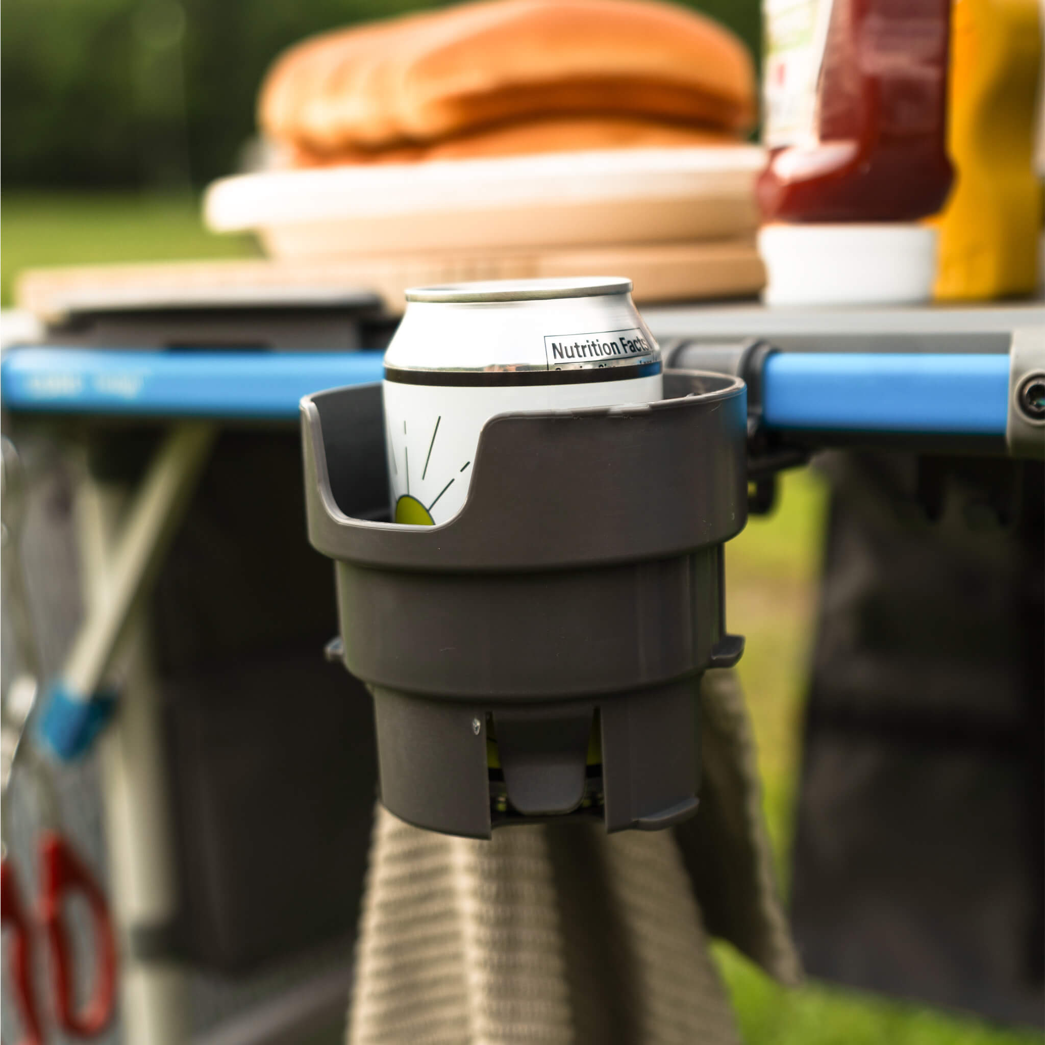 CORE cup holder accessory shown on camp kitchen table holding beverage can beside condiments during outdoor meal prep.