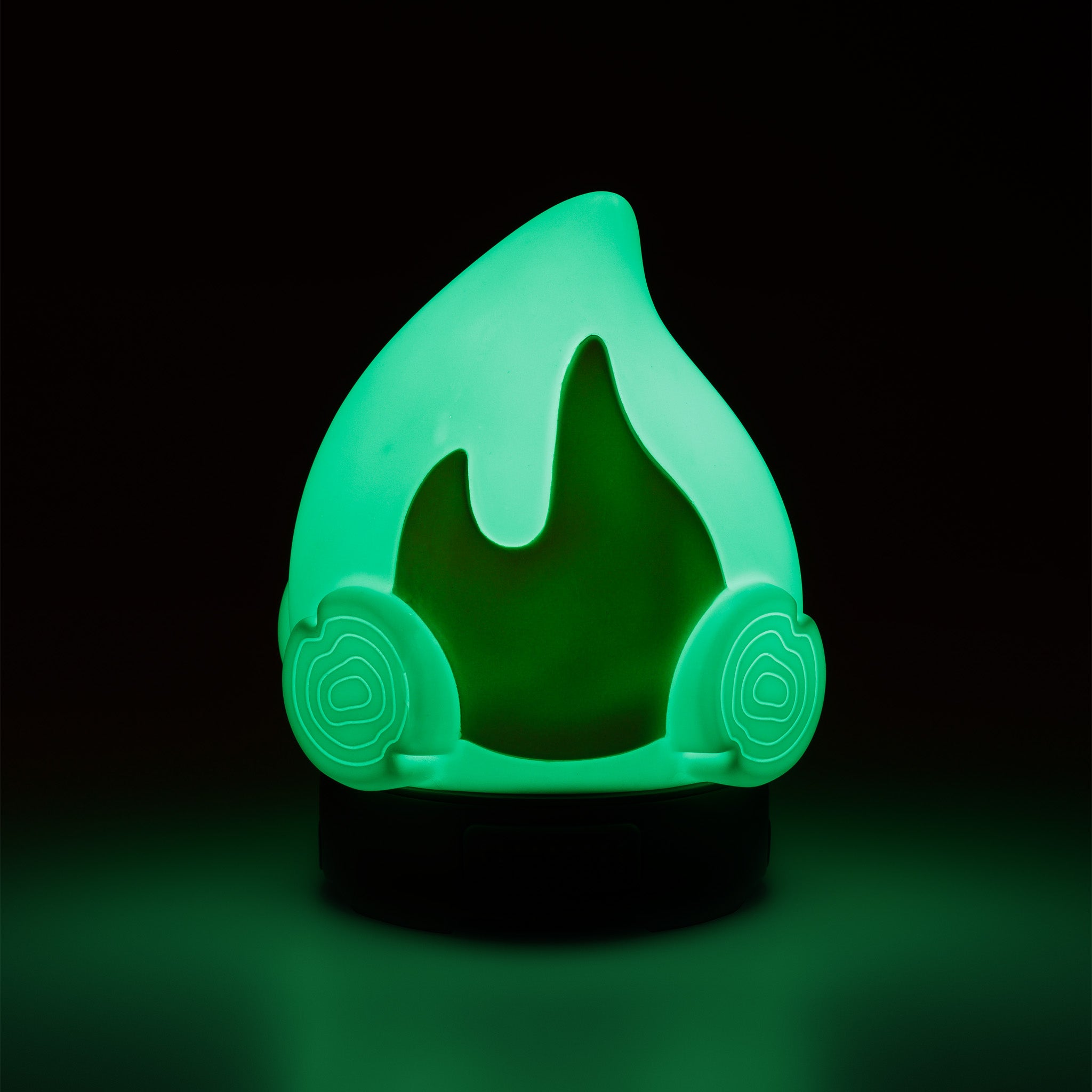 Green flame-shaped lamp on a black background.