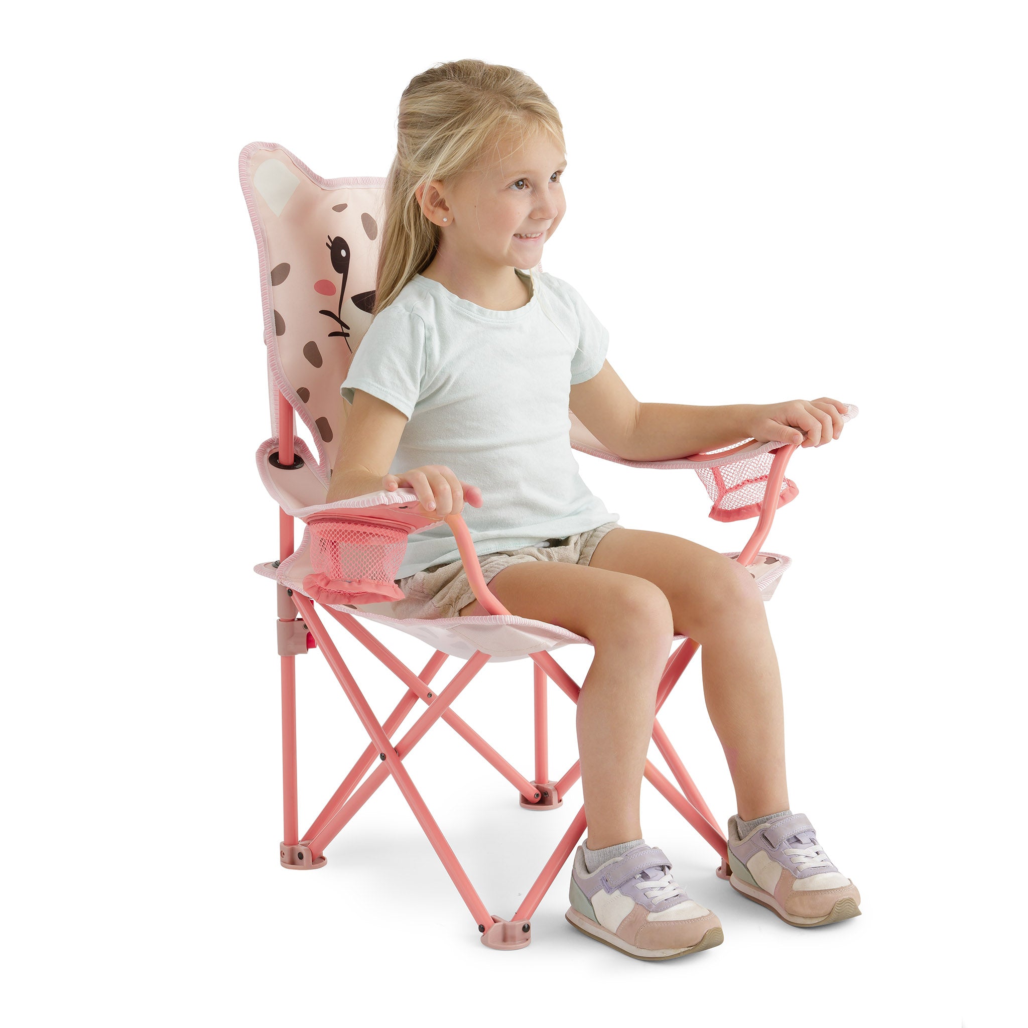 Young child sitting comfortably in the pink kids' cheetah camping chair, showing its child-sized fit, supportive design, and dual mesh cup holders.