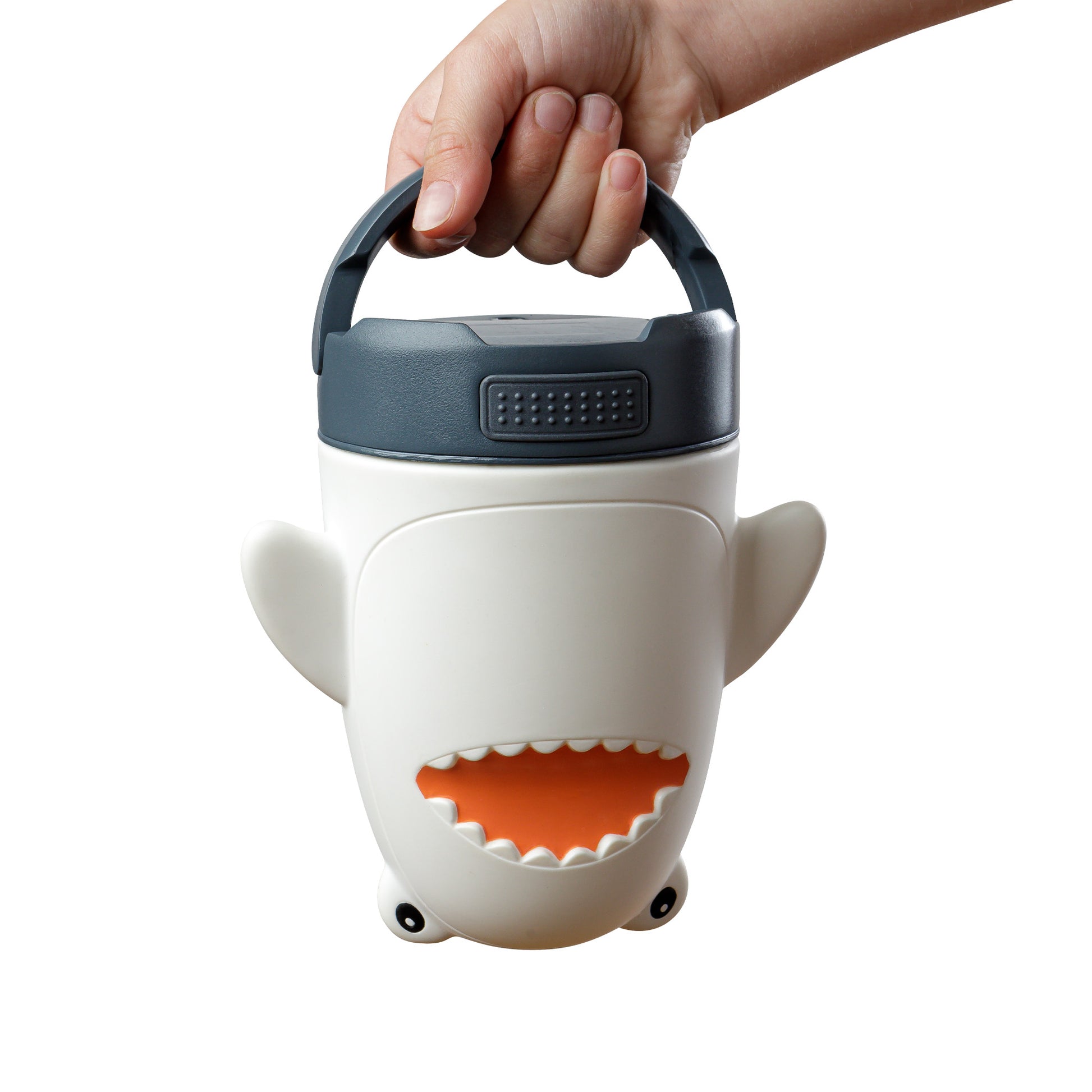 Shark-shaped lantern with a hand holding its handle on a white background.