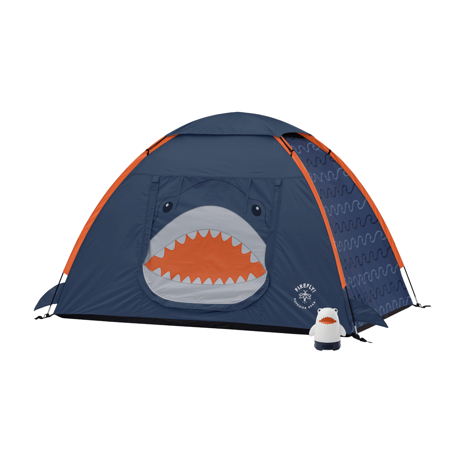 A navy blue dome tent with orange trim, featuring a shark face graphic on the front door and a small white-and-orange shark-shaped accessory lantern placed beside it.