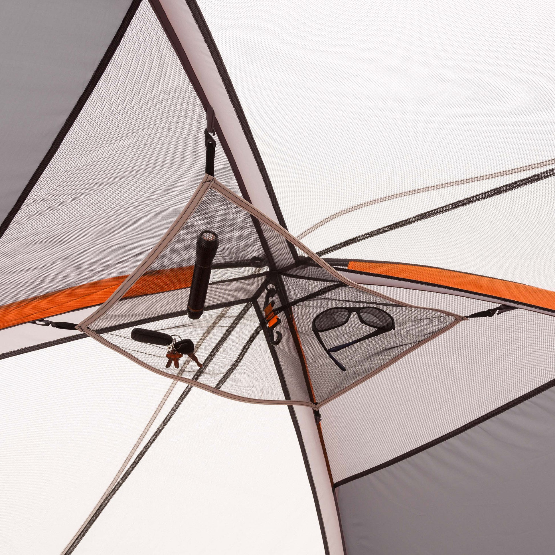 Interior view of a CORE 9 Person Extended Dome Tent showing mesh storage pockets containing various items such as a flashlight, keys, and sunglasses. The tent's structure and seams are visible, with orange and grey fabrics highlighting this outdoor retreat perfect for any camping adventure.