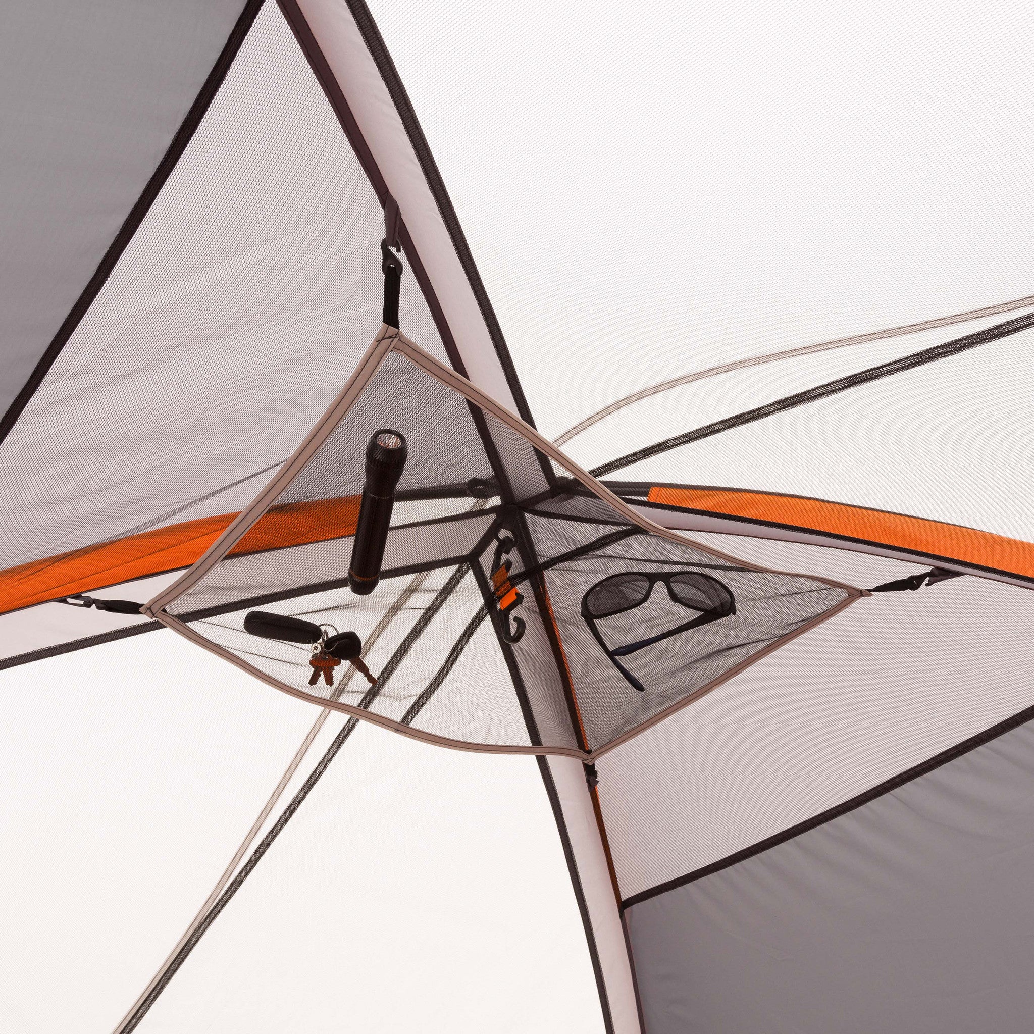 Interior view of a CORE 9 Person Extended Dome Tent showing mesh storage pockets containing various items such as a flashlight, keys, and sunglasses. The tent's structure and seams are visible, with orange and grey fabrics highlighting this outdoor retreat perfect for any camping adventure.