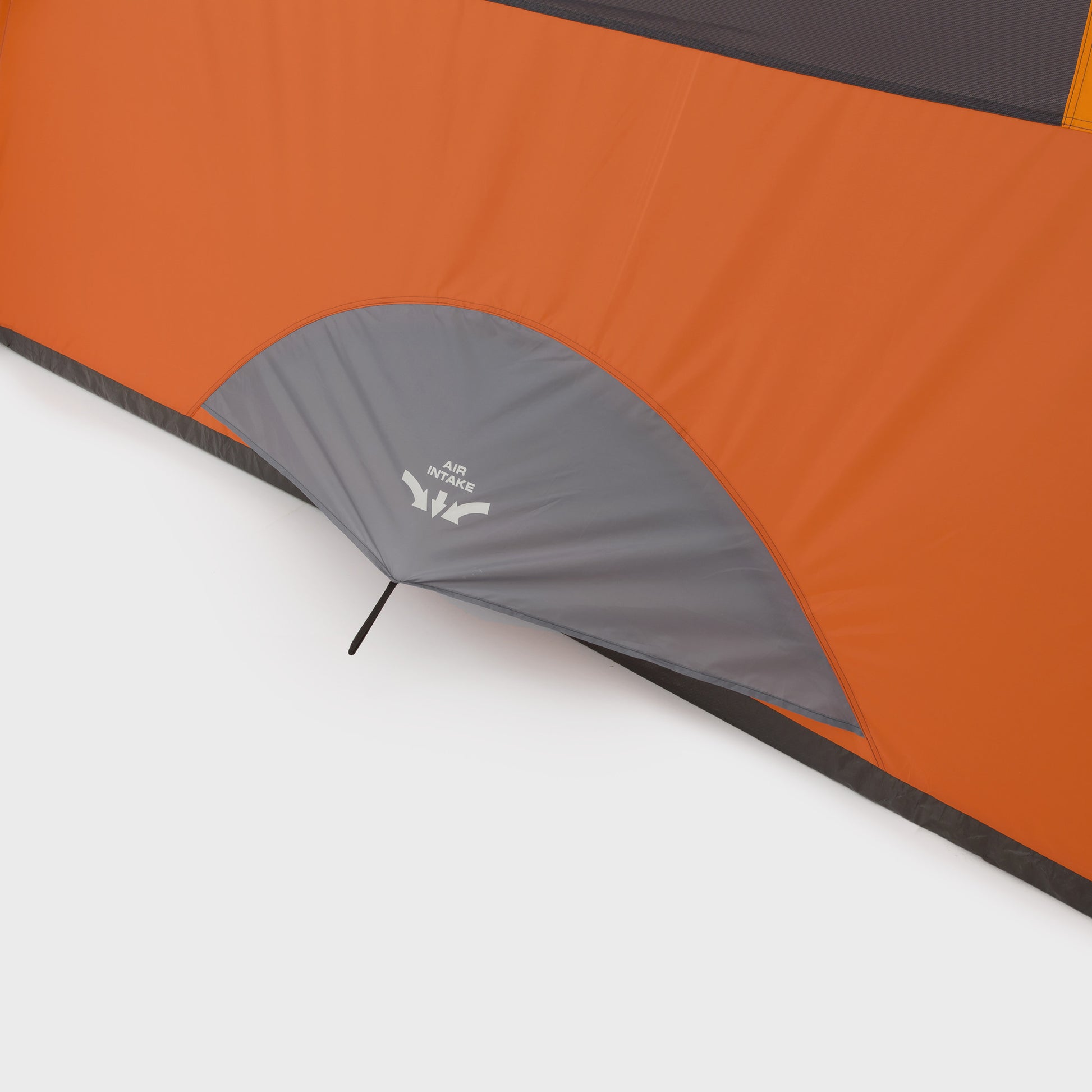  Close-up view of the air intake vent on an orange and gray CORE 9 Person Extended Dome Tent. The vent features a small canopy-like cover with text that says "AIR INTAKE" and an arrow pointing towards the intake opening. The tent fabric, perfect for outdoor adventures, is clearly visible with contrasting colors.