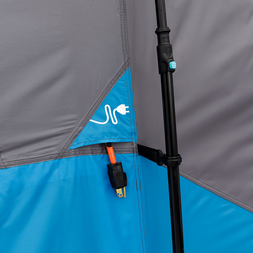 Close-up of an outdoor tent showing a zippered access point with an electrical cord symbol. The zipper is partially open, allowing an orange and black power cord to pass through. The tent fabric, in classic camping colors, is primarily gray and blue. (CORE 9 Person Lighted Instant Cabin Tent)