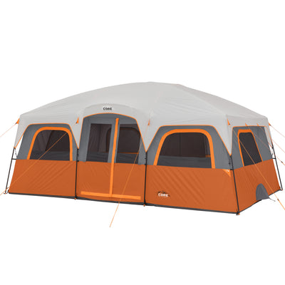 A large outdoor 12 Person Straight Wall Cabin Tent with a gray roof and orange and gray sides. The tent includes multiple windows and doorways, some of which are open. There are guy lines attached to the exterior for stability. The brand "CORE" is visible on the tent.