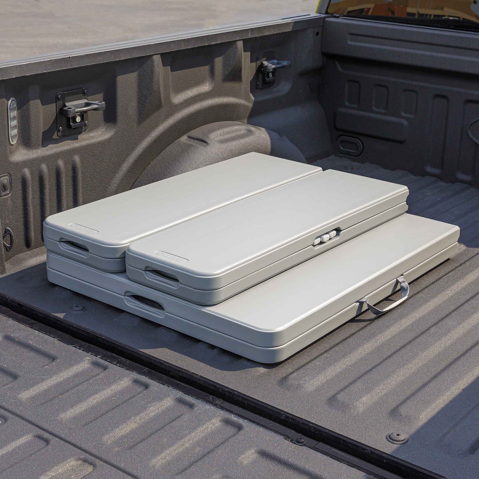 CORE folding picnic table and benches stored compactly in the back of a truck bed.