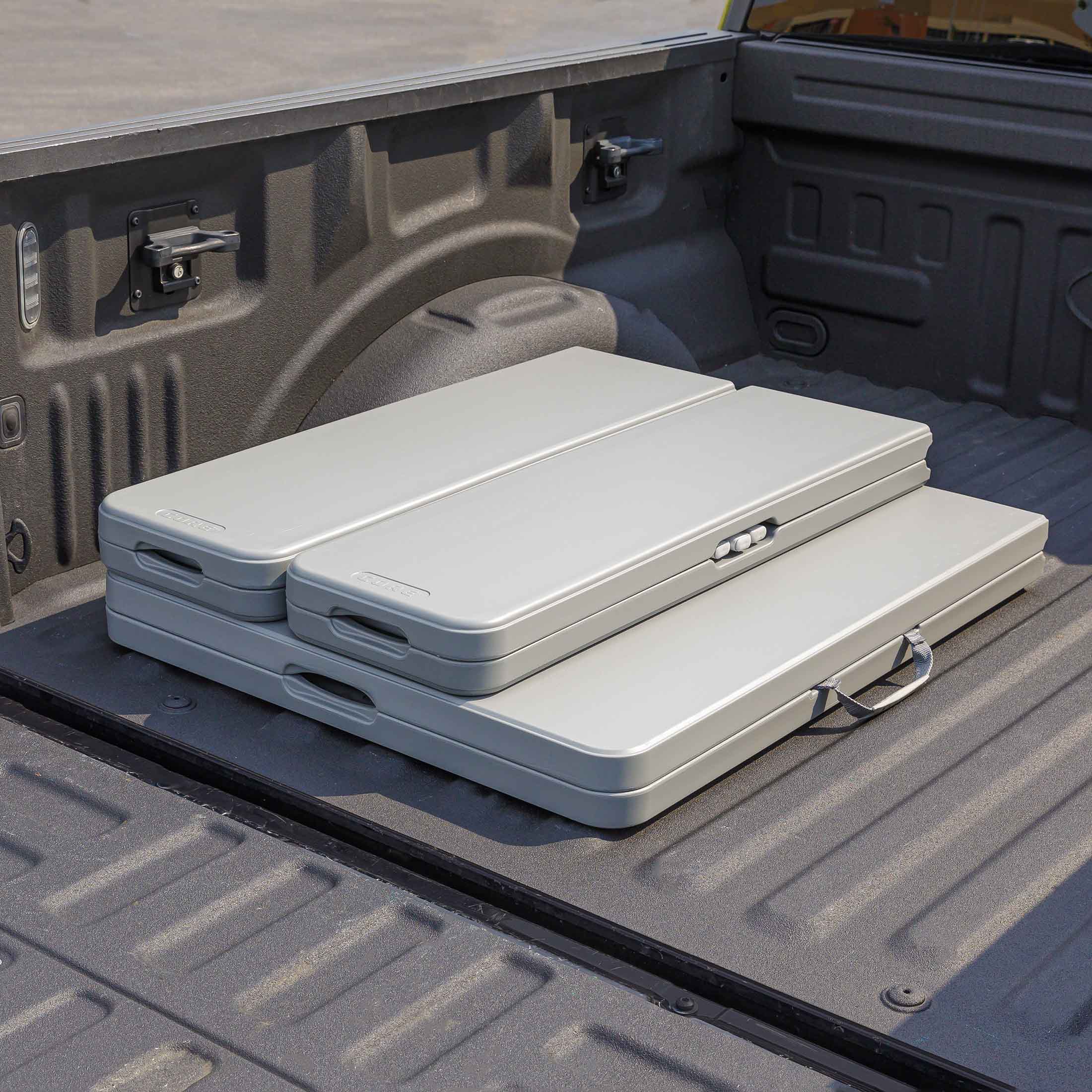 CORE folding picnic table and benches stored compactly in the back of a truck bed.